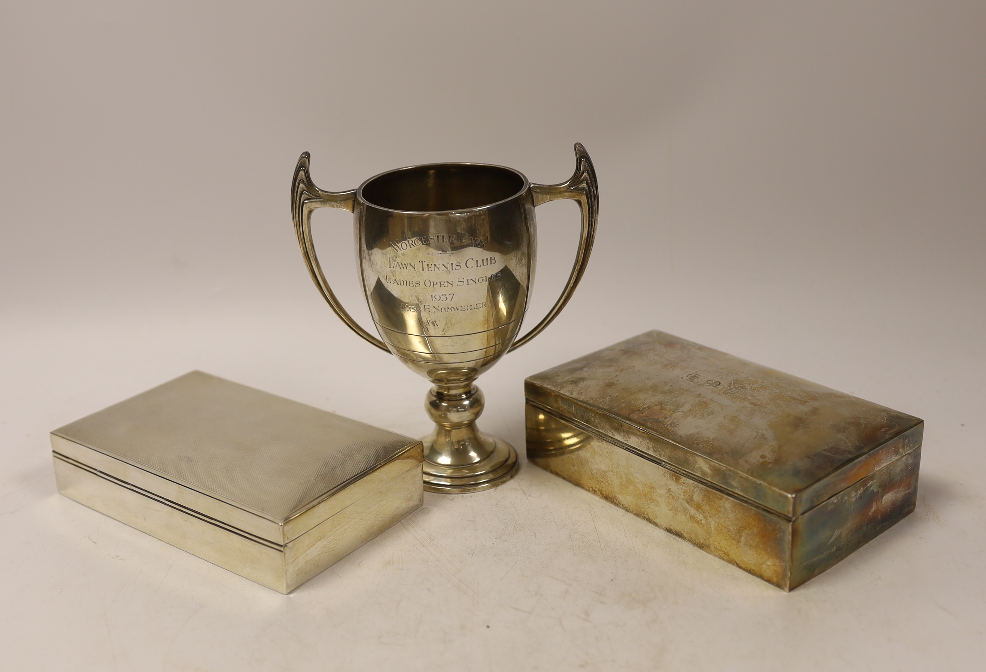 A 1930's Art Deco silver two handled presentation trophy cup, by Mappin & Webb, 15.6cm, and two silver mounted rectangular cigarette boxes.